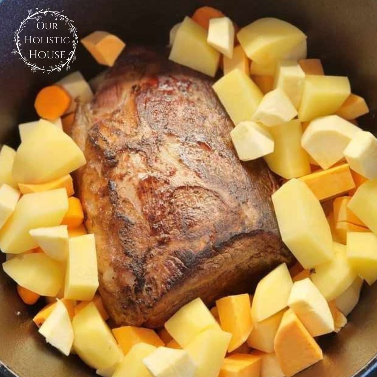 pot roast sitting in a cast iron pot, surrounded by potatoes