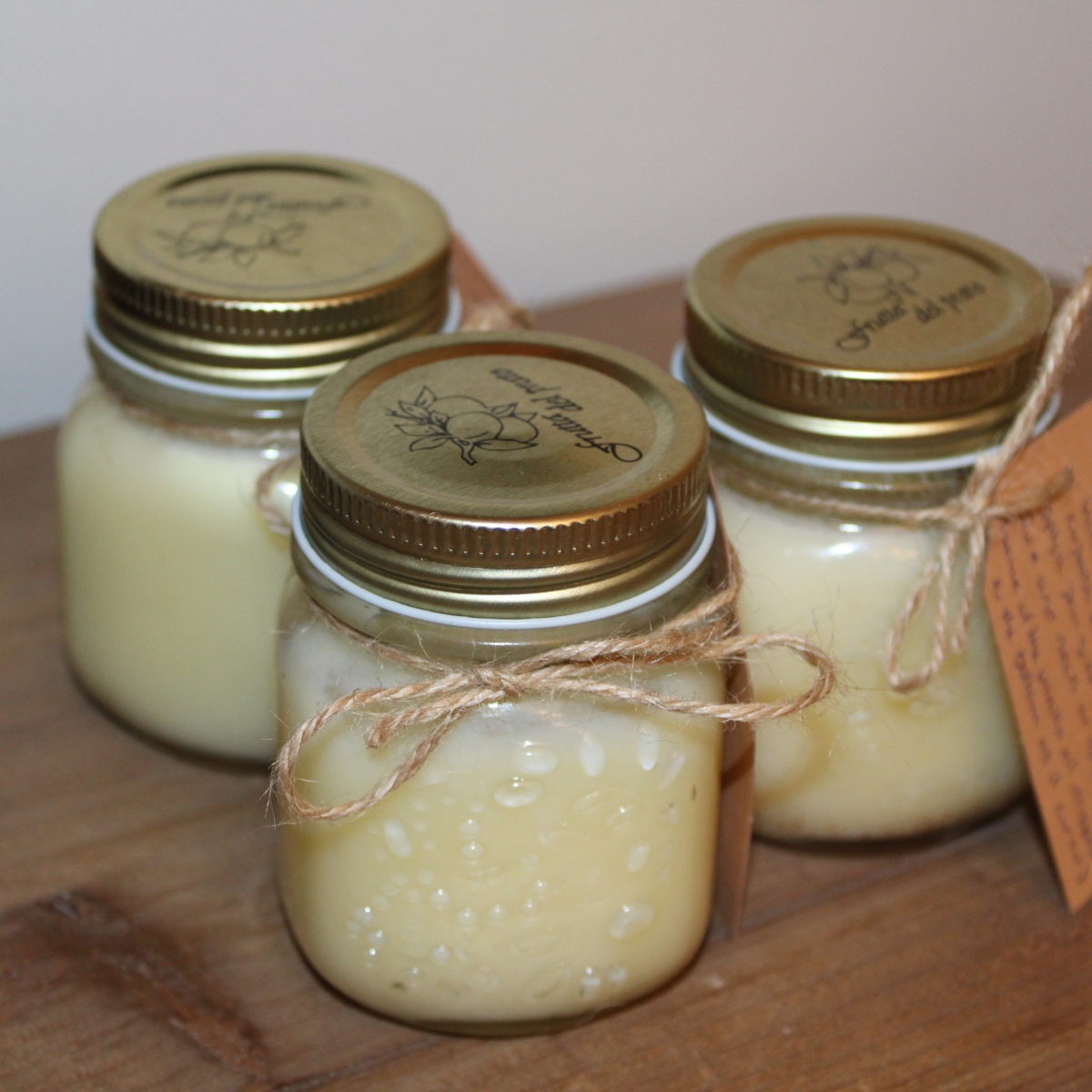 three jars of tallow balm tied with decorative twine