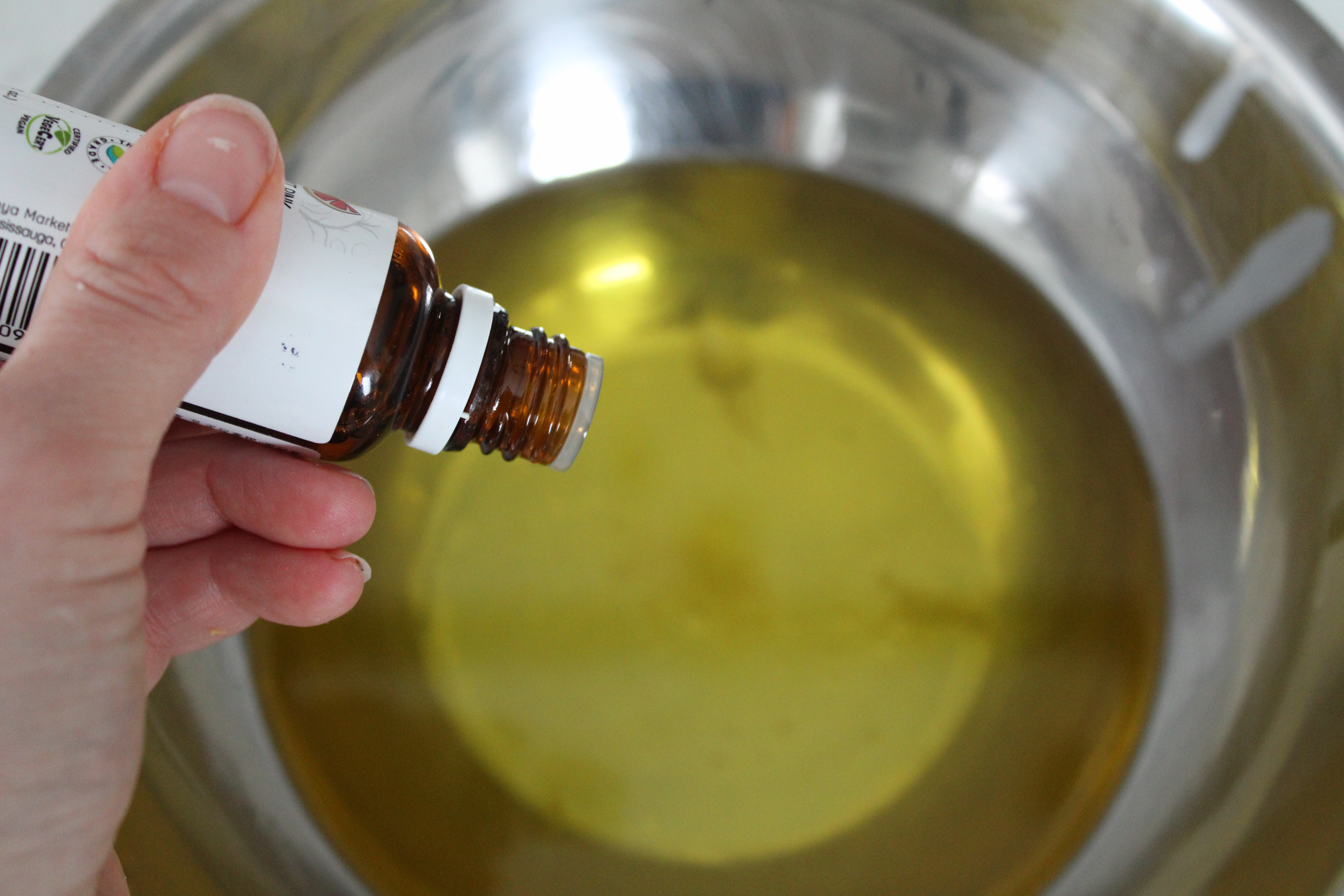 essential oils being poured into melted tallow