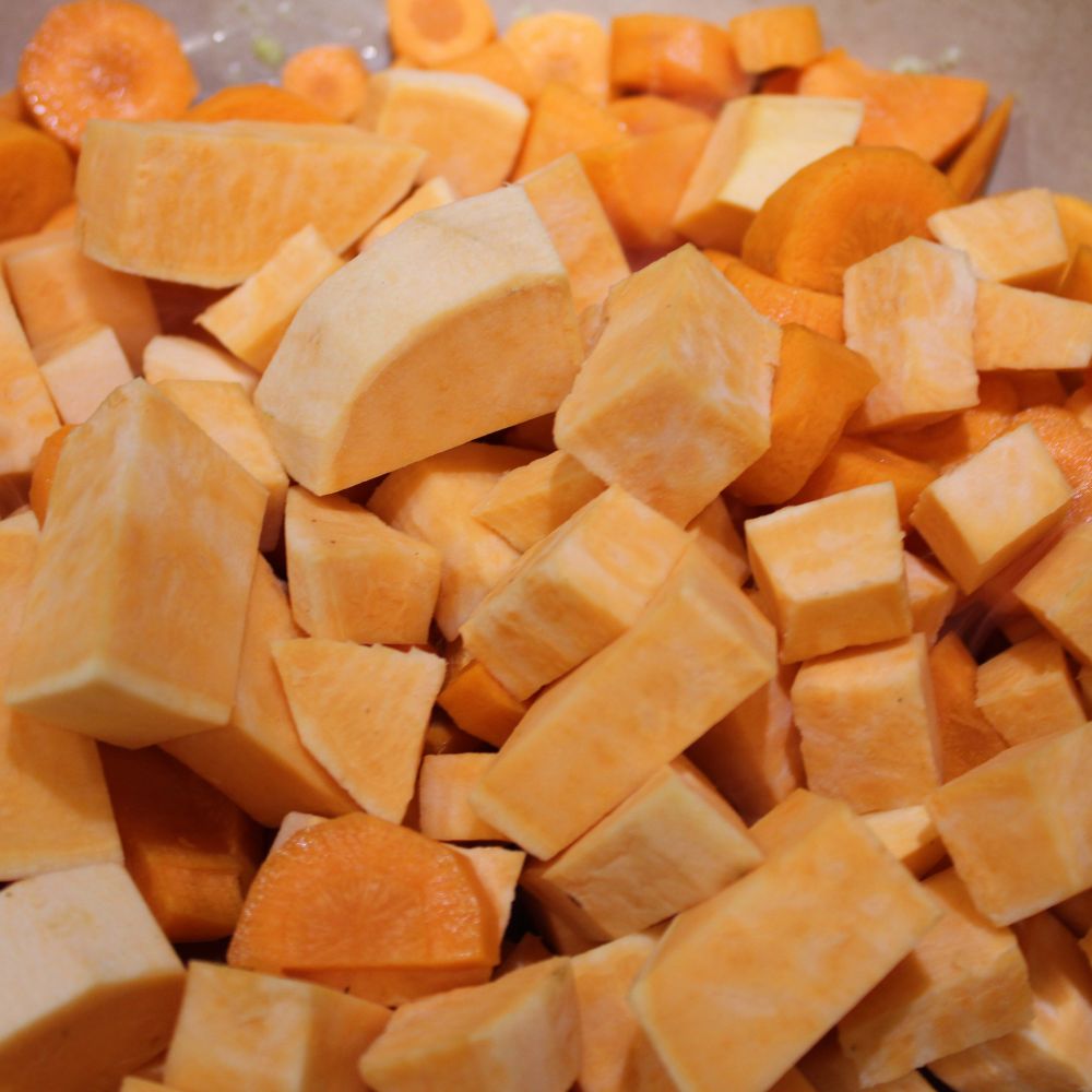 close up of chopped sweet potatoes and carrots in a pot