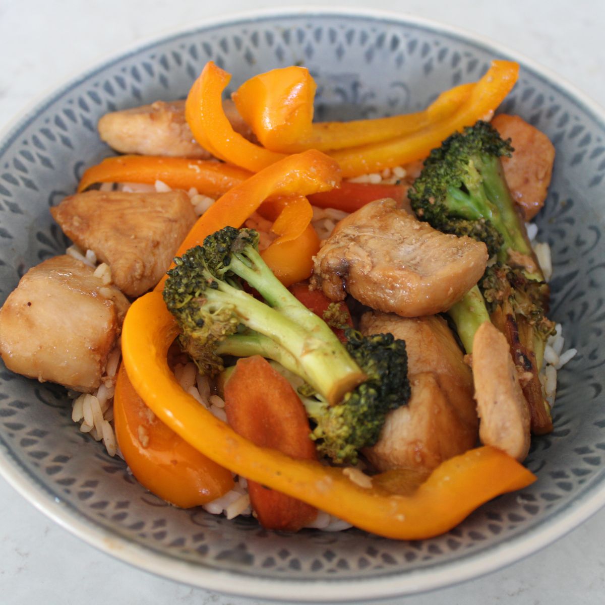 close up of chicken stir fry with orange peppers and broccoli