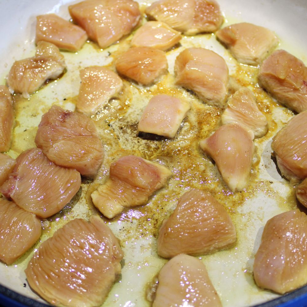 cut up chicken in a frying pan