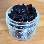 close up of blueberry gummies in a glass jar