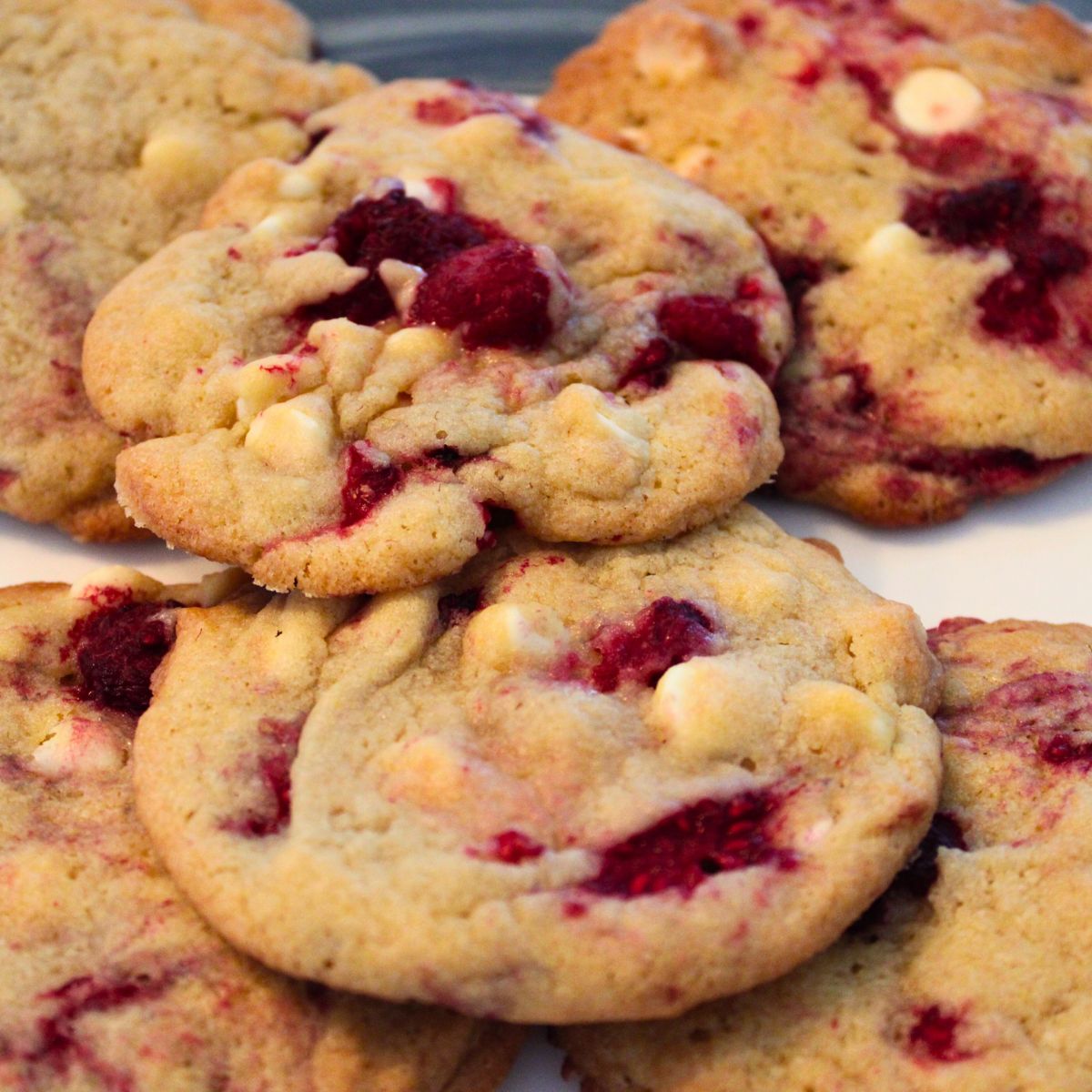 close up of white chocolate chip raspberry cookies on a plate