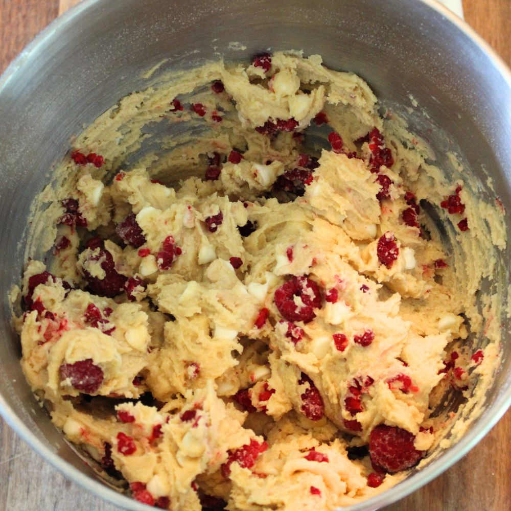 white chocolate chip raspberry cookie dough in the bowl of a stand mixer