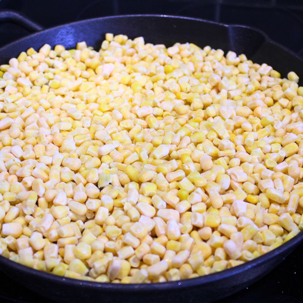 layer of frozen corn on a cast iron skillet