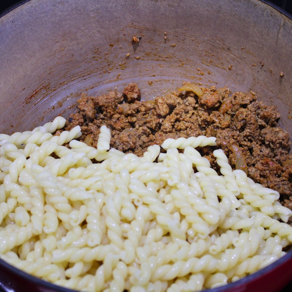 seasoned cooked ground beef with cooked noodles on top